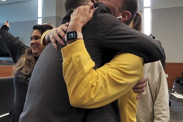 Bravon Tukes' attorney Jamie Deremiah, left, hugs Tukes' mother, Monica Woods, after her son was found not guilty, Friday, Oct. 13, 2023, in Des Moines, Iowa, in a January 2023 shooting at a Des Moines alternative school that left two students dead and the program's founder injured. Philip Joens/The Des Moines Register via AP)