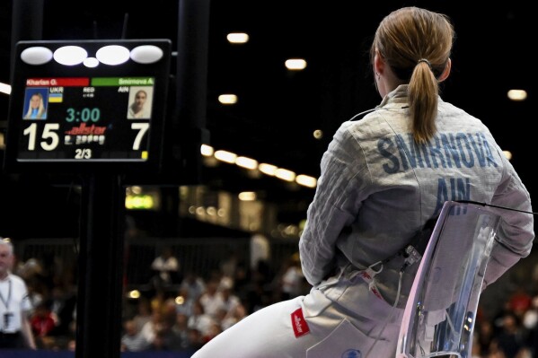 Russia's Anna Smirnova remains seated after her bout with Ukraine's Olga Kharlan in the women's individual sabre best of 64 round match at the World Fencing Championship in Milan, Italy, Thursday, July 27, 2023. Olympic champion Kharlan competed against officially-neutral Russian opponent Smirnova at the world fencing championships, an Olympic qualifier, on Thursday in Milan, Italy, winning their bout 15-7. However, Smirnova refused to leave after the bout in an apparent protest because Kharlan refused to shake hands at the end. (Tibor Illye/MTI via AP)