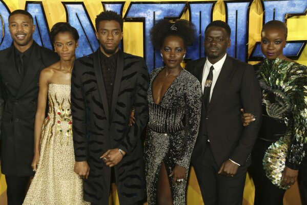 FILE - In this Feb. 8, 2018 file photo, actors Michael B. Jordan, Leitia Wright, Chadwick Boseman, Lupita Nyong'o, Daniel Kaluuya and Danai Gurira pose for photographers upon arrival at the premiere of the film "Black Panther" in London. Boseman, who played Black icons Jackie Robinson and James Brown before finding fame as the regal Black Panther in the Marvel cinematic universe, has died of cancer. His representative says Boseman died Friday, Aug. 28, 2020 in Los Angeles after a four-year battle with colon cancer. He was 43.  (Photo by Joel C Ryan/Invision/AP, File)