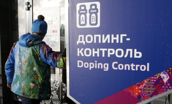 FILE - A man walks past a sign reading “doping control” at the biathlon and cross-country ski center at the 2014 Winter Olympics in Krasnaya Polyana, Russia, Feb. 21, 2014. A subsequent doping scandal tainted the success of the Russian team at the Sochi Olympics (AP Photo/Lee Jin-man, File)