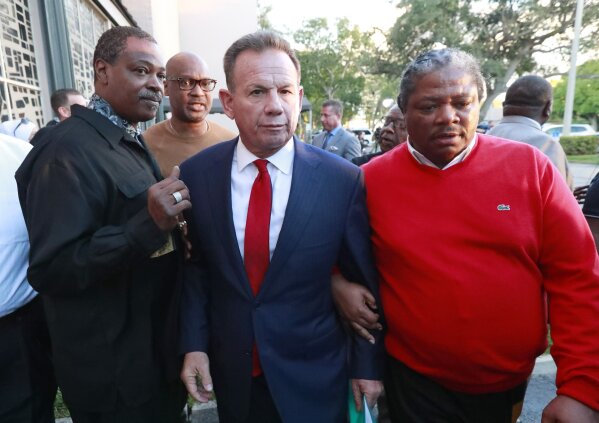 
              Suspended Broward County Sheriff Scott Israel, center, leaves a news conference surrounded by supporters Friday, Jan. 11, 2019, in Fort Lauderdale, Fla., after new Florida Gov. Ron DeSantis suspended him, over his handling of last February's massacre at Marjory Stoneman Douglas High School. (AP Photo/Wilfredo Lee)
            