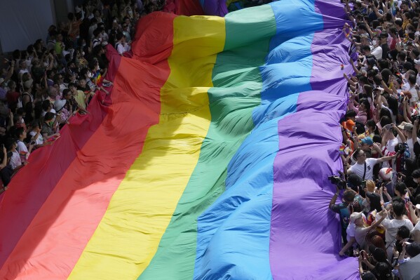 En esta imagen de archivo, participantes en el desfile del Orgullo Gay sostienen una bandera con los colores del arcoíris, símbolo de la comunidad, en Bangkok, Tailandia, el 4 de junio de 2023. (AP Foto/Sakchai Lalit, archivo)