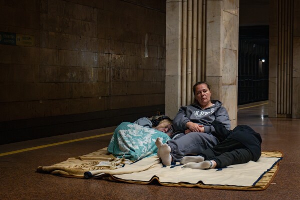 Personas descansan en una estación de metro, utilizada como refugio antiaéreo, durante un ataque con drones rusos en Kiev, Ucrania, la madrugada del viernes 6 de junio de 2025. (Foto AP/Dan Bashakov)