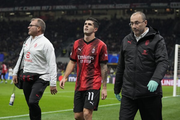 AC Milan's Christian Pulisic, center, leaves the pitch after getting injured during the Champions League group F soccer match between AC Milan and Paris Saint Germain at the San Siro stadium in Milan, Italy, Tuesday, Nov. 7, 2023. (AP Photo/Antonio Calanni)