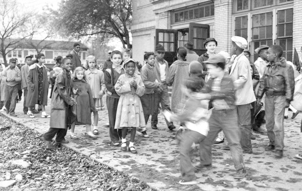 FILE - White and Black children mix freely on the playground outside a school in a racially mixed neighborhood, Oct. 18, 1957, in Detroit. Friday, May 17, 2024, marks 70 years since the U.S. Supreme Court ruled that separating children in schools by race was unconstitutional. On paper, Brown v. Board of Education still stands. In reality, school integration is all but gone, the victim of a gradual series of court cases that slowly eroded it, leaving little behind. (AP Photo/Alvan Quinn, File)