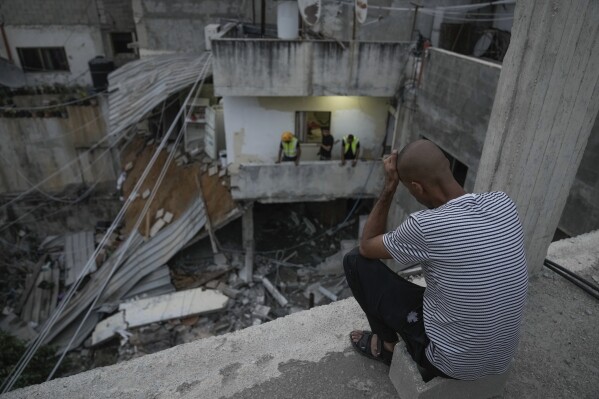 Palestinians inspect a damaged building following an Israeli army raid in Nour Shams refugee camp in the northern West Bank, Sunday, Sept. 24, 2022. Palestinians said at least two people were killed in the raid, which the army said was carried out to destroy a militant command center and bomb-storage facility in the building. (AP Photo/Majdi Mohammed)