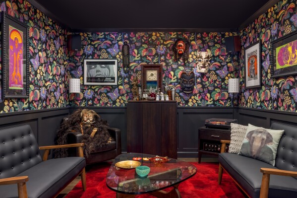 This photo provided by Clara Jung of Banner Day Interiors in San Francisco shows a cozy den with a vintage wood bar, a sprawl-worthy crimson rug, and Schumacher’s Exotic Butterfly wallpaper. (Vivian Johnson/Banner Day Interiors via AP)