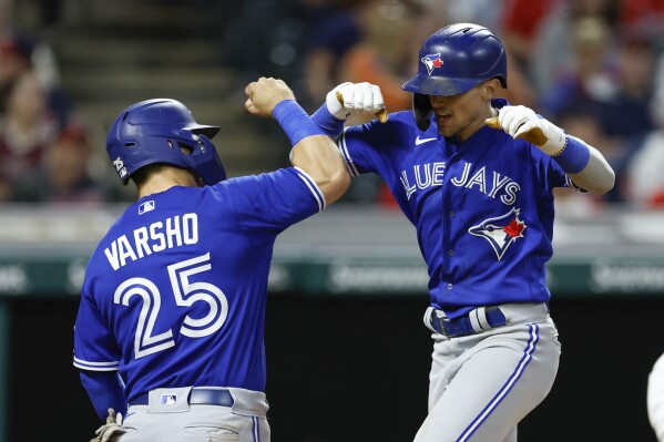 Toronto Blue Jays' Cavan Biggio celebrates with Daulton Varsho (25) after hitting a two-run home run off Cleveland Guardians relief pitcher Enyel De Los Santos during the eighth inning of a baseball game, Monday, Aug. 7, 2023, in Cleveland. (AP Photo/Ron Schwane)