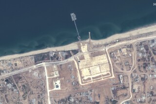 This image released by Maxar Technologies shows the overview of the new pier off Gaza and aid trucks on Saturday, May 18, 2024. (Satellite image ©2024 Maxar Technologies via AP)