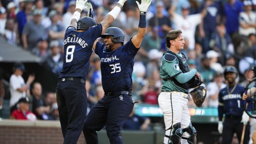National League's Elias Díaz, of the Colorado Rockies (35), celebrates his two run home run with Nick Castellanos (8), of the Philadelphia Phillies, in the eighth inning during the MLB All-Star baseball game in Seattle, Tuesday, July 11, 2023. (AP Photo/Lindsey Wasson)