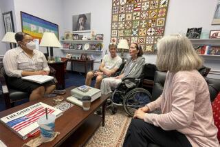 In this photo provided by Becky Mourey, Becky Mourey, center, and her husband Jim, left, meet with representatives for Illinois Rep. Jan Schakowsky at her offices on Capitol Hill, Washington DC in May 2022. Mourey and other ALS patients spent more than two years advocating for the approval of the new drug, Relyvrio, a treatment for ALS. Patients say they are now facing insurance and financial hurdles to access the drug, which costs $158,000. (Nicole Cimbura via AP)