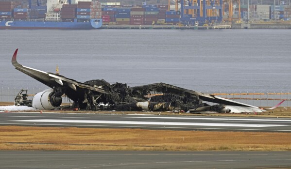 The burn-out Japan Airlines plane is seen at Haneda airport on Wednesday, Jan. 3, 2024, in Tokyo, Japan. The large passenger plane and a Japanese coast guard aircraft collided on the runway at Tokyo's Haneda Airport on Tuesday and burst into flames, killing several people aboard the coast guard plane, officials said. (Kyodo News via AP)