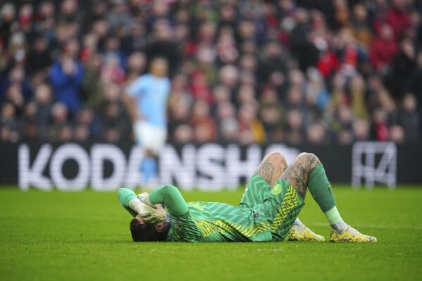 Manchester City's goalkeeper Ederson lies on the ground after an injuring during the English Premier League soccer match between Liverpool and Manchester City, at Anfield stadium in Liverpool, England, Sunday, March 10, 2024. (AP Photo/Jon Super)