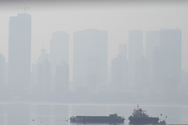 Boats are seen anchored in the Arabian Sea as morning smog envelops the skyline in Mumbai, India, Thursday, Nov. 2, 2023. (AP Photo/Rafiq Maqbool)