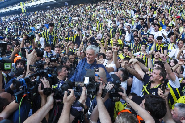 Huấn luyện viên bóng đá người Bồ Đào Nha Jose Mourinho, ở giữa, tạo dáng trước giới truyền thông cùng những người ủng hộ trong buổi thuyết trình chính thức với tư cách là huấn luyện viên mới Fenerbahce của Thổ Nhĩ Kỳ tại sân vận động Sukru Saracoglu ở Istanbul, Thổ Nhĩ Kỳ, Chủ nhật, ngày 2 tháng 6 năm 2024. Mourinho đã ký hợp đồng hai năm với Fenerbahce.  (Ảnh AP)