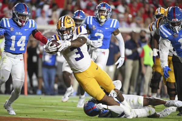 LSU running back Logan Diggs (3) dives for a touchdown past Mississippi safety Trey Washington, bottom, during the second half of an NCAA college football game in Oxford, Miss., Saturday, Sept. 30, 2023. (AP Photo/Thomas Graning)
