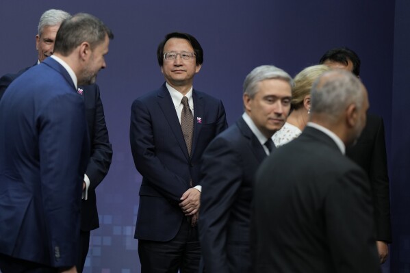 Wu Zhaohui, third left, Chinese Vice Minister of Science and Technology looks on as other delagats takes their places for the family photo during the AI Saftey Summit in Bletchley Park, Milton Keynes, England, Wednesday, Nov. 1, 2023. (AP Photo/Alastair Grant)