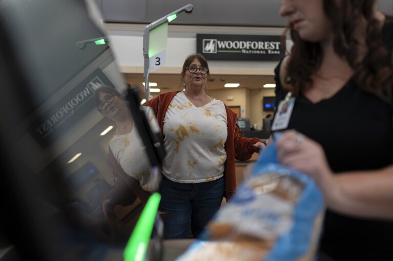 Jodi Ferdinandsen looks to Family Resource Center peer support worker Jesse Johnson as she helps her check out at Walmart in Findlay, Ohio, Thursday, Oct. 12, 2023. (AP Photo/Carolyn Kaster)