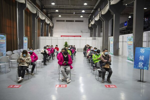 In this photo released by Xinhua News Agency, residents wait to receive their COVID-19 vaccinations at a temporary vaccination site in Beijing, Saturday, Jan. 2, 2021. China authorized its first homegrown COVID-19 vaccine for general use on Dec. 31, 2020, adding another shot that could see wide use in poorer countries as the virus surges back around the globe. (Chen Zhonghao/Xinhua via AP)