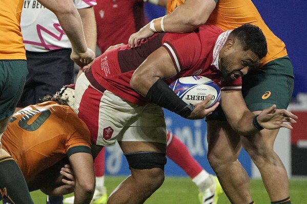 Wales' Taulupe Faletau is tackled by during a Rugby World Cup Pool C match against Australia at the Parc OL stadium in Lyon, France, Sunday, Sept. 24, 2023. (AP Photo/Laurent Cipriani)