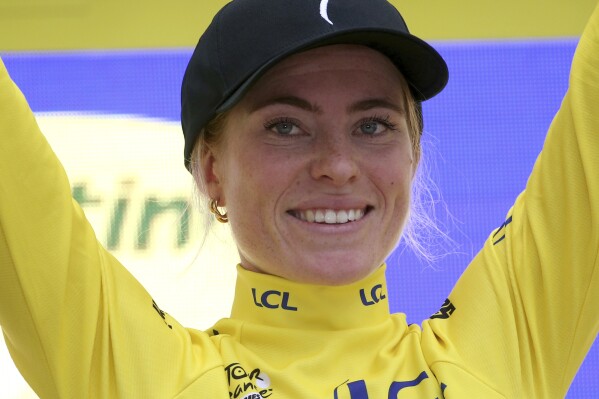 Netherland's Demi Vollering wearing the overall leader's yellow jersey celebrates on the podium after winning the Tour de France women's cycling race, an individual time trial over 22.6 kilometers (14 miles) with start and finish in Pau, southwestern France, Sunday, July 30, 2023. (AP Photo/Bob Edme)
