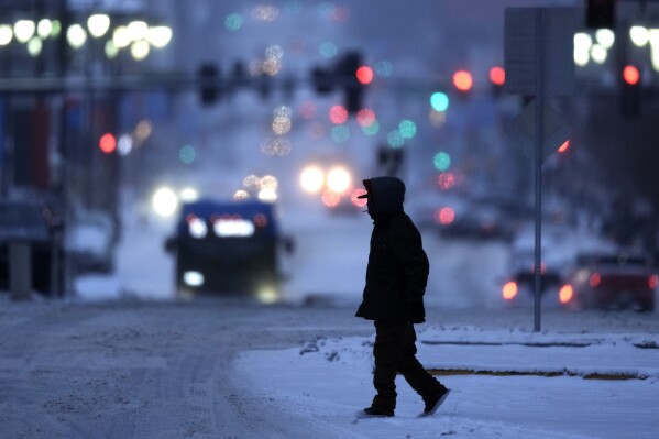 On Monday, January 15, 2024 in Downtown Kansas City, MO.  (AP Photo/Charlie Riddell) A pedestrian braves sub-zero temperatures while walking.