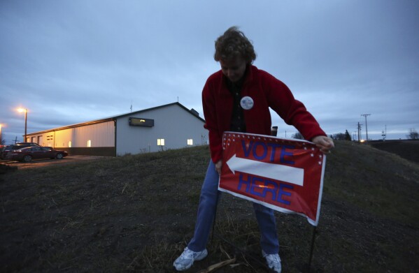File - Election Judge Victoria Colwell Location A "vote here" Enter the grounds in front of the Argusville, ND, Firehall Community Center in rural Cass County just before voting began on Election Day, November 6, 2012.  North Dakota will become the first state to require hand counting of all election ballots.  If voters support the proposed ballot measure, it would achieve the goal of activists across the country who distrust modern vote counting.  (AP Photo/LM Otero, File)