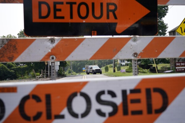 A roadblock is seen as crews search for a pair of missing children swept away after weekend rains, Monday, July 17, 2023, in Washington Crossing, Pa. (AP Photo/Matt Slocum)