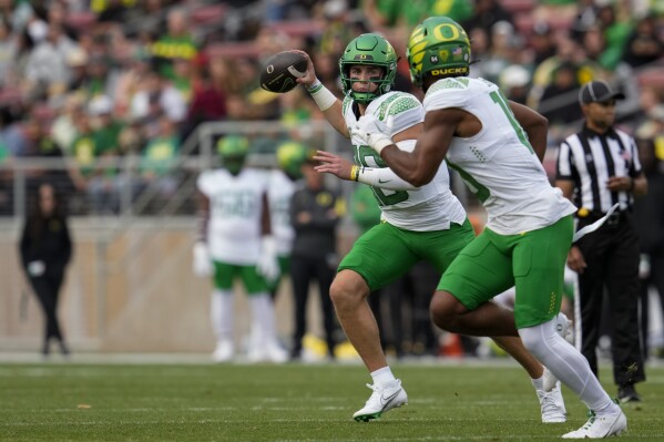 Oregon quarterback Bo Nix throws the ball to Oregon tight end Kenyon Sadiq, foreground right, during the first half of an NCAA college football game against Stanford on Saturday, Sept. 30, 2023, in Stanford, Calif. (AP Photo/Godofredo A. Vásquez)