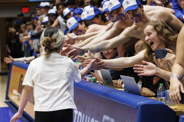 Samantha DiMartino, 10, gets high-fives from fans in the Duke student section after being honored as a part of the Scheyer Family Kid Captains Program, which recognizes patients and families of Duke Children's Hospital, during a timeout at an NCAA college basketball game between Duke and Louisville in Durham, N.C., Wednesday, Feb. 28, 2024. (AP Photo/Ben McKeown)