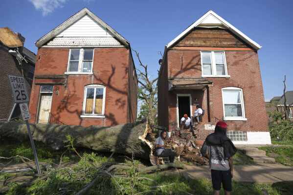 People survey damage after a severe storm moved through Friday, May 16, 2025, in St. Louis. (AP Photo/Jeff Roberson)