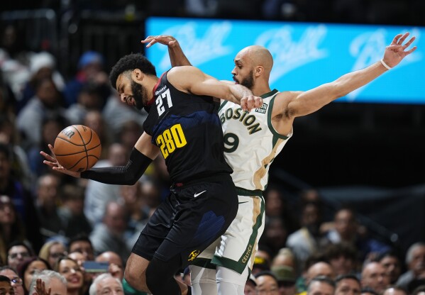 Denver Nuggets guard Jamal Murray, left, and Boston Celtics guard Derrick White collide while chasing a loose ball in the first half of an NBA basketball game Thursday, March 7, 2024, in Denver .  (AP Photo/David Zalubowski)