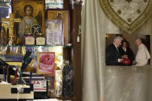 A picture of Italian tailor Raniero Mancinelli and Pope Francis hangs inside Mancinelli's shop in Rome, Wednesday, April 30, 2025. (AP Photo/Gregorio Borgia)