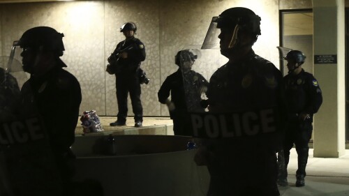 FILE - Phoenix Police stand in front of police headquarters on May 30, 2020, in Phoenix, waiting for protesters marching to protest the death of George Floyd. A federal judge has ruled that an Arizona law limiting how close people can get to recording law enforcement is unconstitutional, citing a clearly established right to film police doing their jobs. The ruling Friday, July 21, 2023 from U.S. District Judge John J. Tuchi permanently blocks enforcement of the law that he suspended last year (AP Photo/Ross D. Franklin, File)