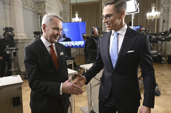 The two candidates with the most preliminary votes, National Coalition Party candidate Alexander Stubb, right, and Social Movement candidate Pekka Haavisto shake hands during a Presidential election event, at the Helsinki City Hall, in Helsinki, Finland, Sunday, Jan. 28, 2024. A projection in Finland says Alexander Stubb has won the first round of the presidential election to set up a Feb 11 runoff. ((Markku Ulander/Lehtikuva via AP)