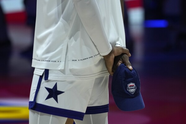 A player from the U.S. holds a hat to exchange as a gift before a Basketball World Cup semi final game against Germany in Manila, Philippines, Friday, Sept. 8, 2023. (AP Photo/Aaron Favila)