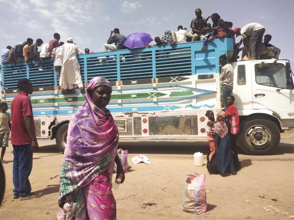FILE - People board a truck as they leave Khartoum, Sudan, on June 19, 2023. Clashes resumed between Sudan's military and a powerful paramilitary force after a three-day cease-fire expired Wednesday morning, June 21, 2023, a protest group and residents reported. (AP Photo, File)
