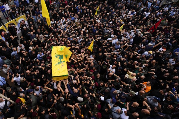 Hezbollah fighters carry the coffin of their comrade, Mohammed Ali Assaf, who was killed by an Israeli strike in Syria Friday morning, during his funeral procession in the southern Beirut suburb of Dahiyeh, Lebanon, Saturday, Nov. 11, 2023. Lebanon's militant Hezbollah group has announced the death of seven of its fighters without giving details on where they were killed. A Hezbollah official and a Lebanese security official said the seven fighters were killed in neighboring Syria Friday morning. (AP Photo/Hassan Ammar)