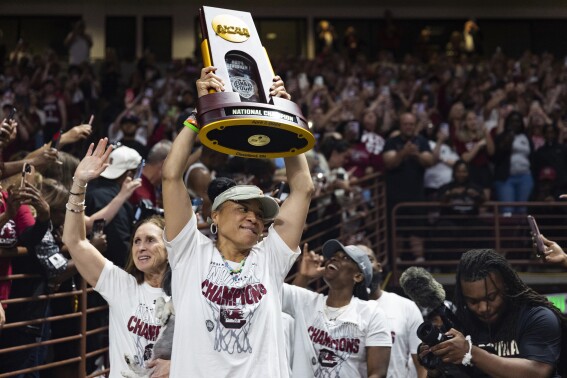South Carolina basketball coach Dawn Staley carries the NCAA college women's basketball championship trophy around Colonial Life Arena, in Columbia, S.C., Monday, April 8, 2024. South Carolina defeated Iowa to win the national title. (Joshua Boucher/The State via AP)