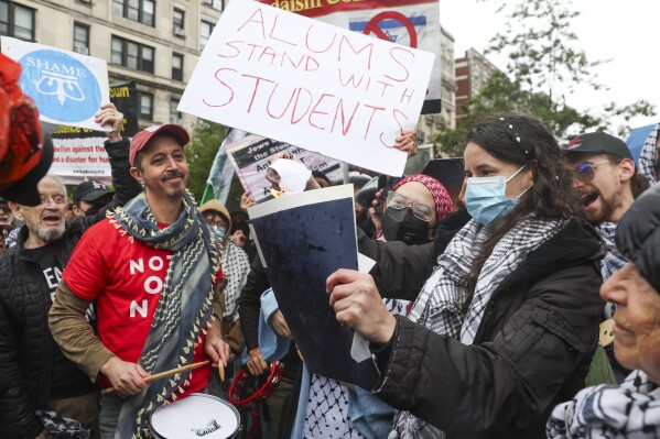 Alumni and students will burn their diplomas across the street from the main gate of Columbia University in New York on Wednesday, May 21, 2025. (AP Photo/Heather Khalifa)