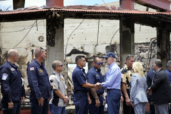 FILE - President Joe Biden and first lady Jill Biden greet first responders as they visit areas devastated by the Maui wildfires, Aug. 21, 2023, in Lahaina, Hawaii. The White House is asking lawmakers for more than $23 billion in emergency funding to help the government respond to the natural disasters that have ripped through the U.S. this year. (AP Photo/Evan Vucci, File)