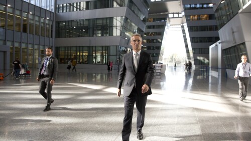 FILE - NATO Secretary General Jens Stoltenberg, center, walks in the Agora Hall as he arrives for his first day of work at the new NATO headquarters in Brussels on May 7, 2018. NATO Secretary General Jens Stoltenberg, the top civilian official at the world's biggest security alliance, routinely praises allies for helping Ukraine's troops to fight back. But when he does, Stoltenberg is talking about individual member countries, not NATO as an organization. (AP Photo/Virginia Mayo, File)