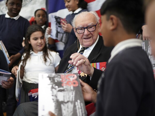 D-Day veteran and Ambassador for the British Normandy Memorial, Ken Hay, 98, who served with the 4th Dorset Regiment, speaks to children during a visit to Rush Green Primary School in Dagenham, England, Monday May 20, 2024, ahead of the 80th anniversary of the D-Day landings. (Gareth Fuller/PA via AP)