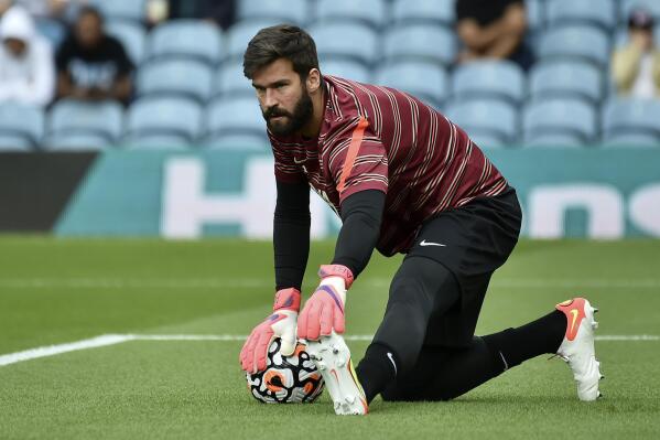Liverpool's goalkeeper Alisson stretches during warmup before the English Premier League soccer match between Leeds United and Liverpool at Elland Road, Leeds, England, Sunday, Sept. 12, 2021. (AP Photo/Rui Vieira)