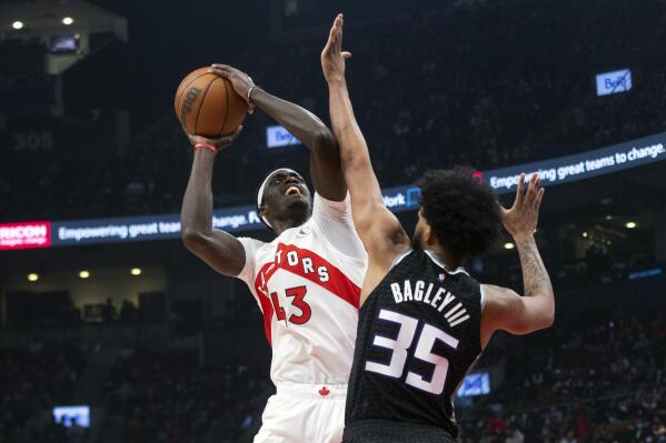 Toronto Raptors' Pascal Siakam, left, scores on Sacramento Kings' Marvin Bagley III during the first half of an NBA basketball game in Toronto, Monday, Dec. 13, 2021. (Chris Young/The Canadian Press via AP)