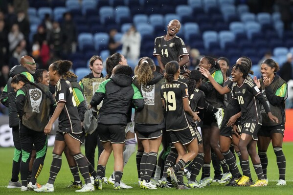 Jamaica's Deneisha Blackwood, top, celebrates with her teammates after the Women's World Cup Group F soccer match between France and Jamaica at the Sydney Football Stadium in Sydney, Australia, Sunday, July 23, 2023. The match ended in a 0-0 draw. (AP Photo/Mark Baker)