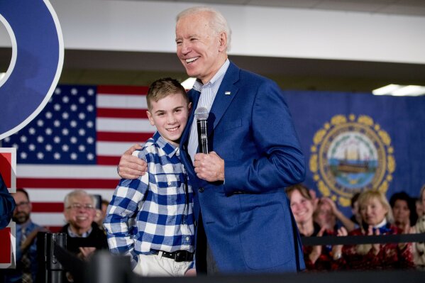 FILE - Then Democratic presidential candidate former Vice President Joe Biden hugs Brayden Harrington at a campaign stop in Gilford, N.H. on Feb. 10, 2020. Harrington, who will be part of a primetime inaugural special, has a book coming out this summer. His picture story “Brayden Speaks Up” will be released Aug. 10. (AP Photo/Andrew Harnik, File)