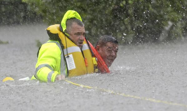 Wilford Martinez, right, is rescued from his flooded car by Harris County Sheriff's Department Richard Wagner along Interstate 610 in floodwaters from Tropical Storm Harvey on Sunday, Aug. 27, 2017, in Houston, Texas. (AP Photo/David J. Phillip)