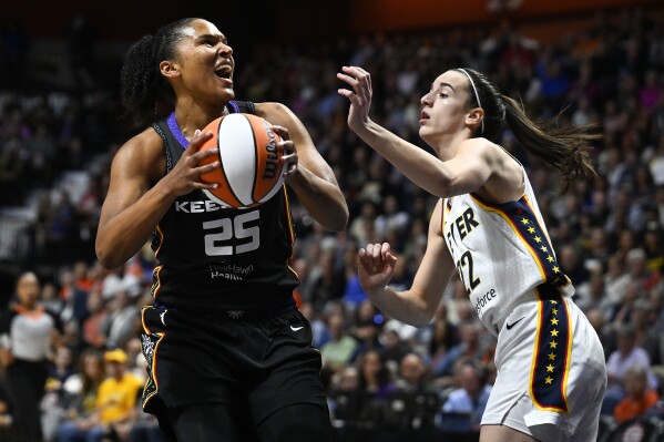 Connecticut Sun forward Alyssa Thomas (25) looks to shoot against Indiana Fever guard Caitlin Clark (22) during the first quarter of a WNBA basketball game, Tuesday, May 14, 2024, in Uncasville, Conn. (AP Photo/Jessica Hill)