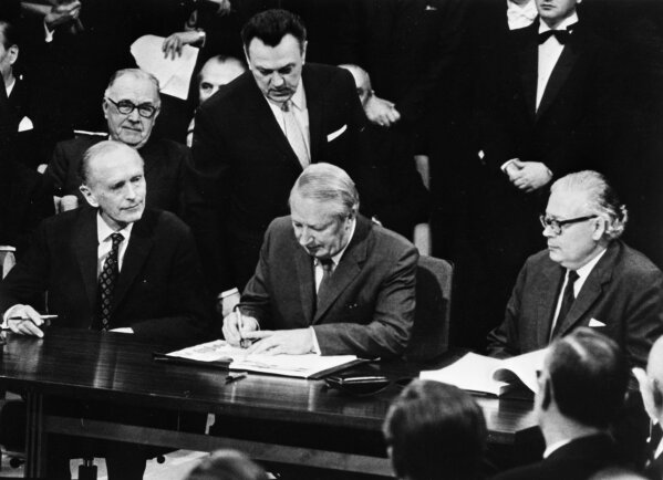FILE - In this Jan. 22, 1972 file photo, British Prime Minister Edward Heath, center, signs the treaty for Britain to join the European Economic Community at the Palais d'Egmont in Brussels, Belgium. Following the Brexit vote in 2016, Britain's membership of what became known as the European Union, is scheduled to end on Jan. 31, 2020.  (AP Photo, File)